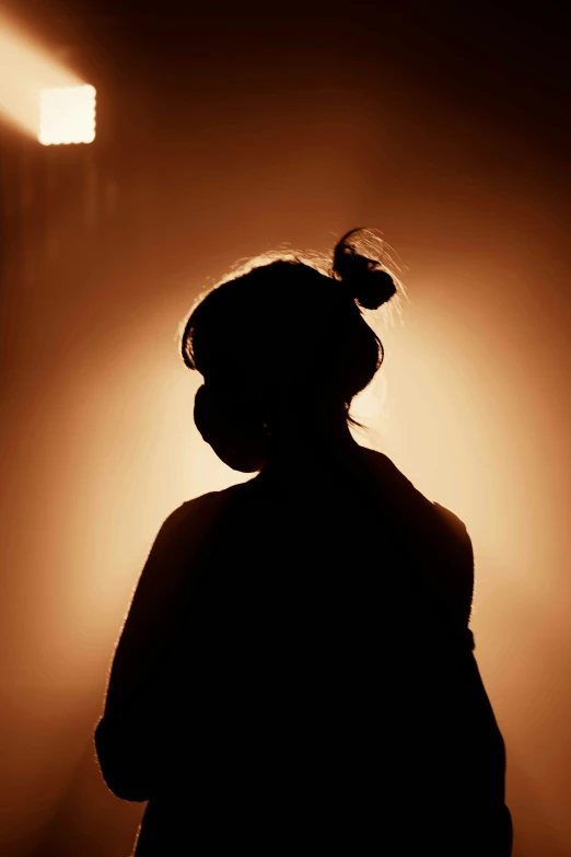 a person with their hair pulled up under some lighting
