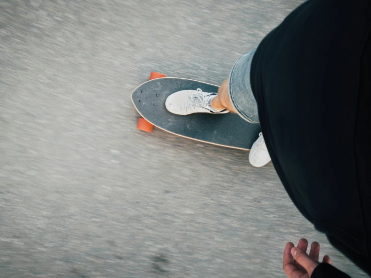 person riding skateboard down paved surface in urban setting