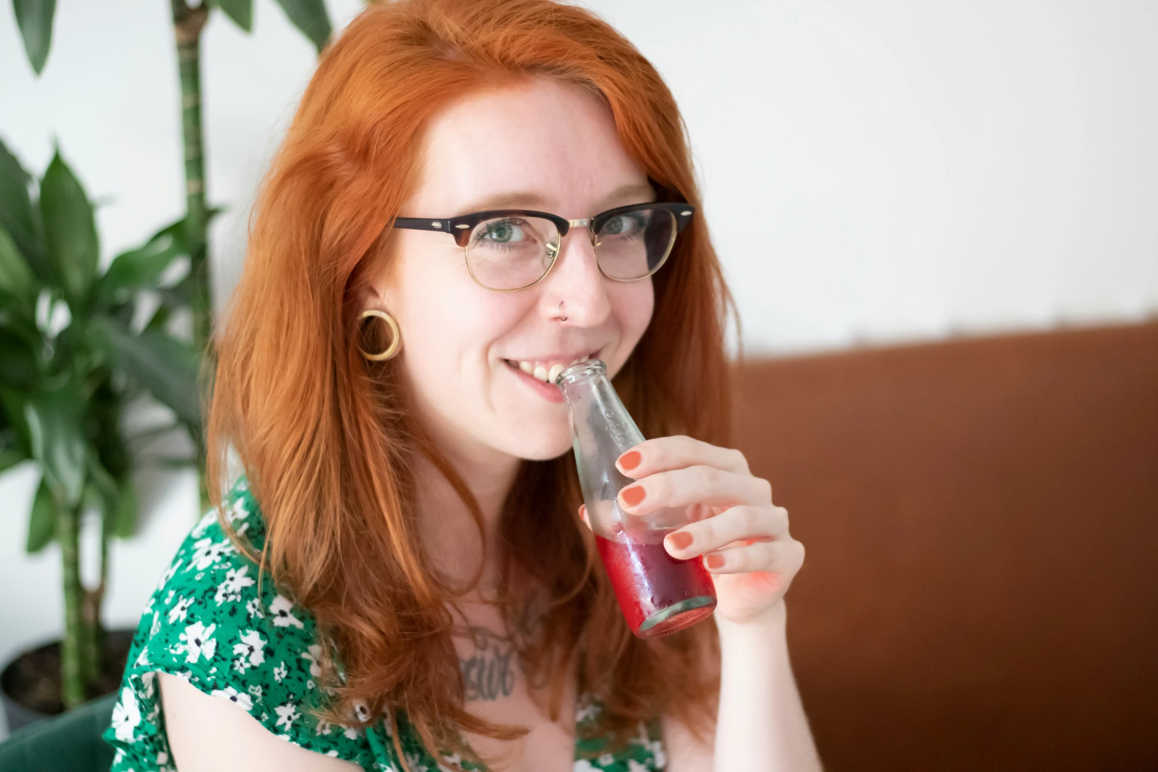 a woman with glasses holding a drink in her hand