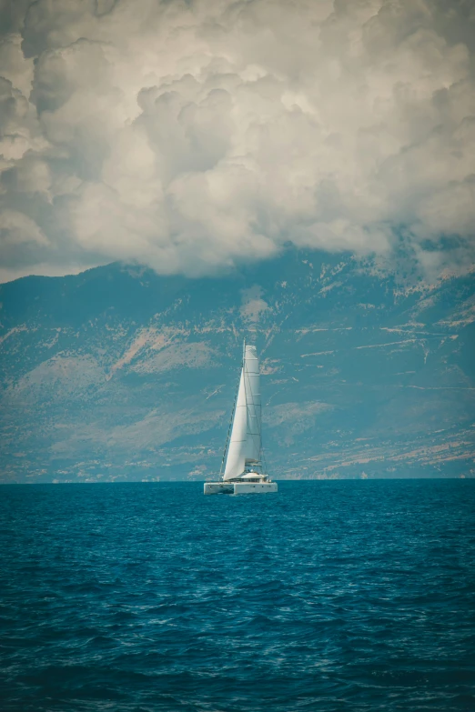 a white boat sailing on top of the ocean