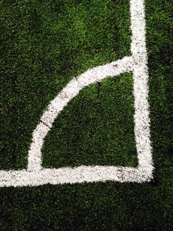 the corner of a tennis court made out of grass