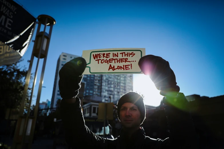 a man holds up a sign that says make in this terrible name