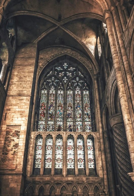 stained glass window with man praying in cathedral