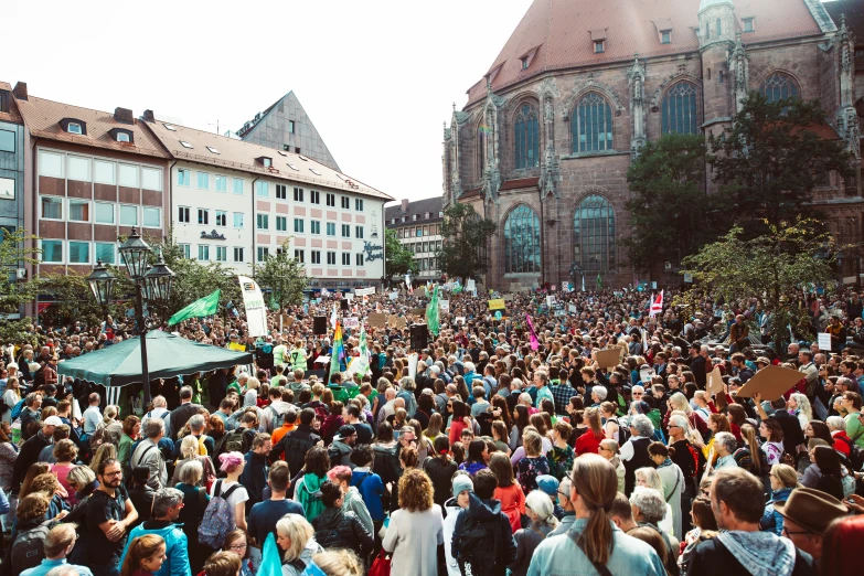 a large crowd gathers in front of some old buildings