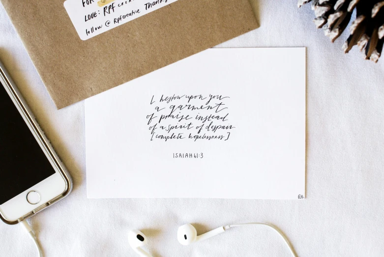 a white envelope with a handwritten note and ear buds