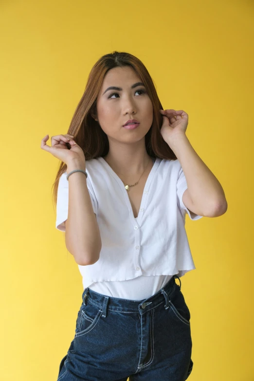 a young woman posing for a po with her hands on her hair