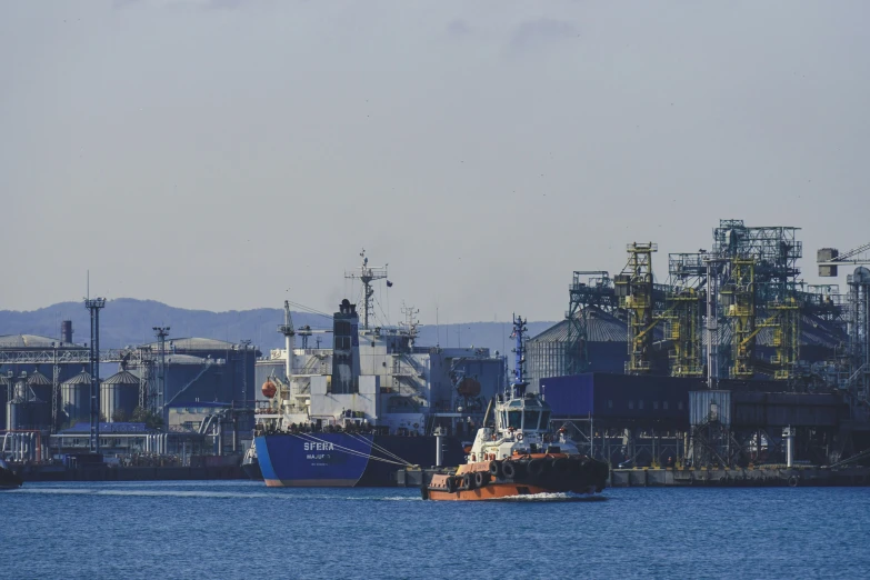 a boat on water in front of large factory