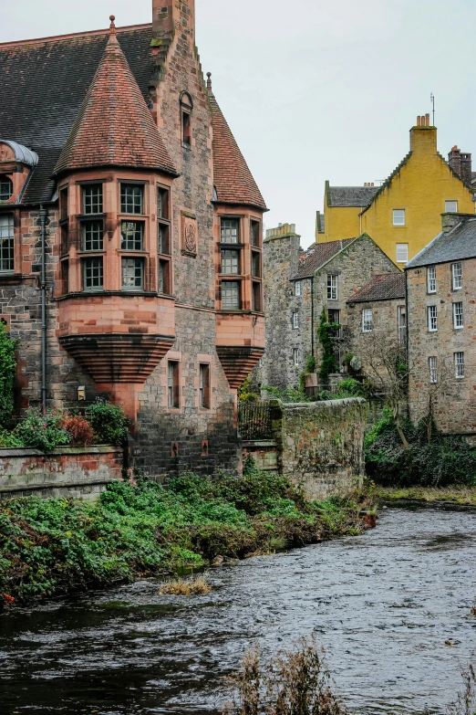 old style houses next to a river with a stone bridge