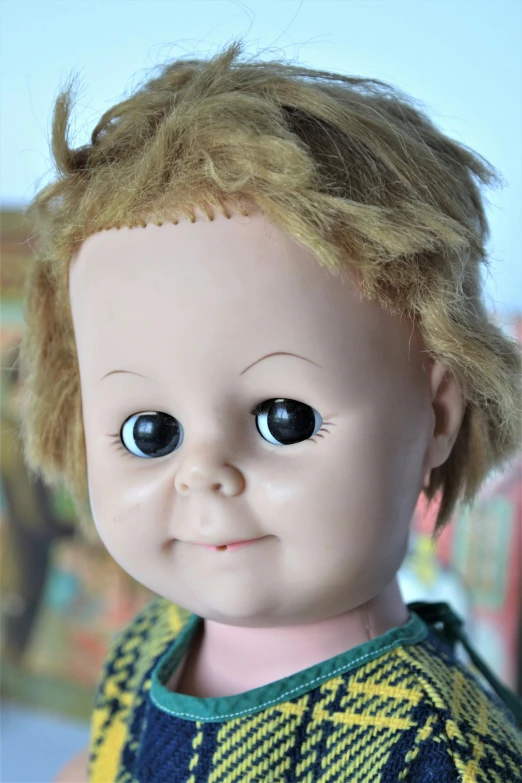 a doll with blonde hair wearing a green sweater