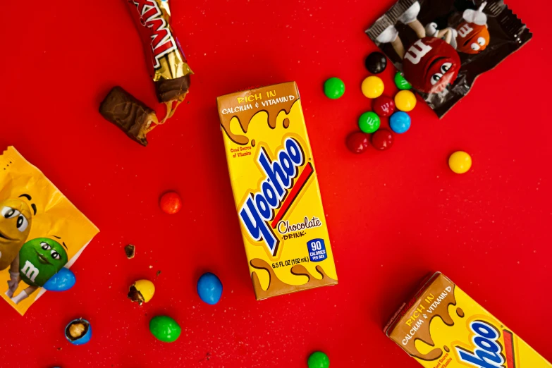 a variety of candy on a red table with chocolate and marshmallows