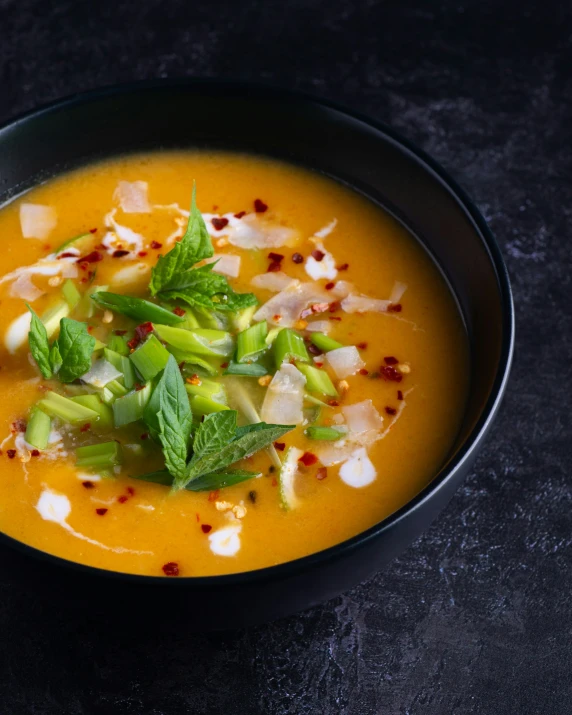 there is a black bowl filled with red and white soup