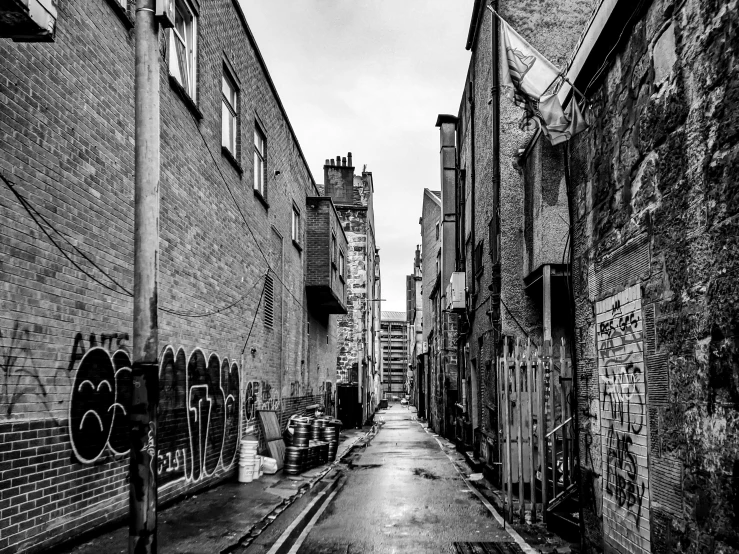 an alleyway with brick buildings with graffiti