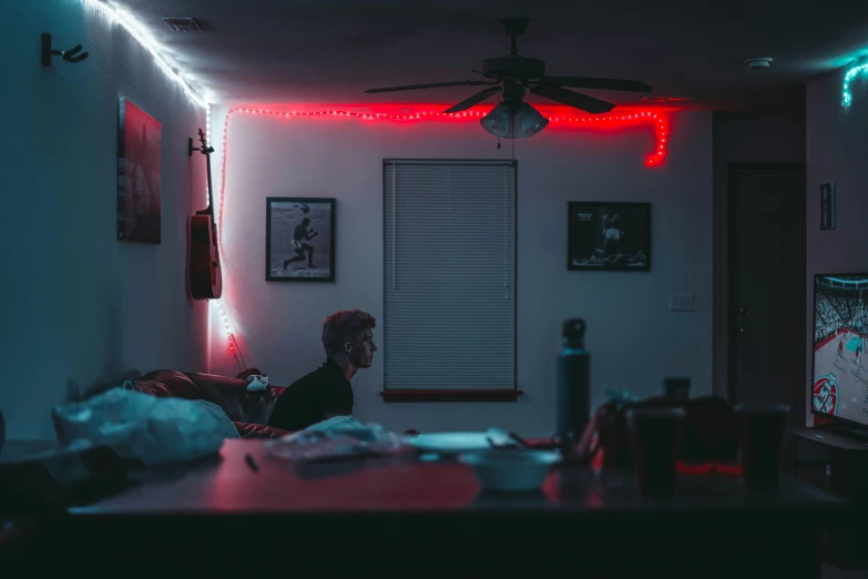 a man sitting on his bed in the dark