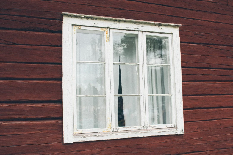 an old window on the side of a brown wooden house