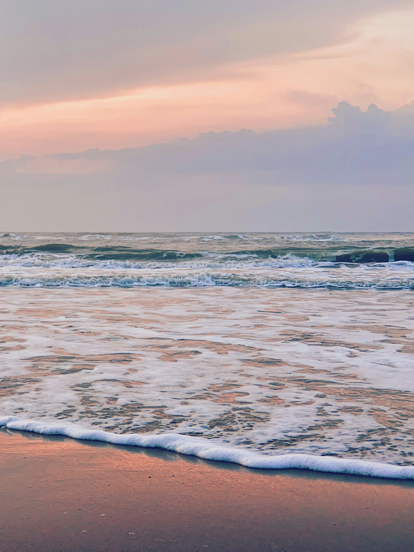 a person with surf board on beach next to ocean