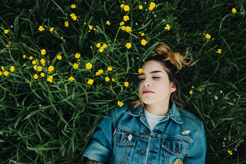 young woman laying in grass and looking upward