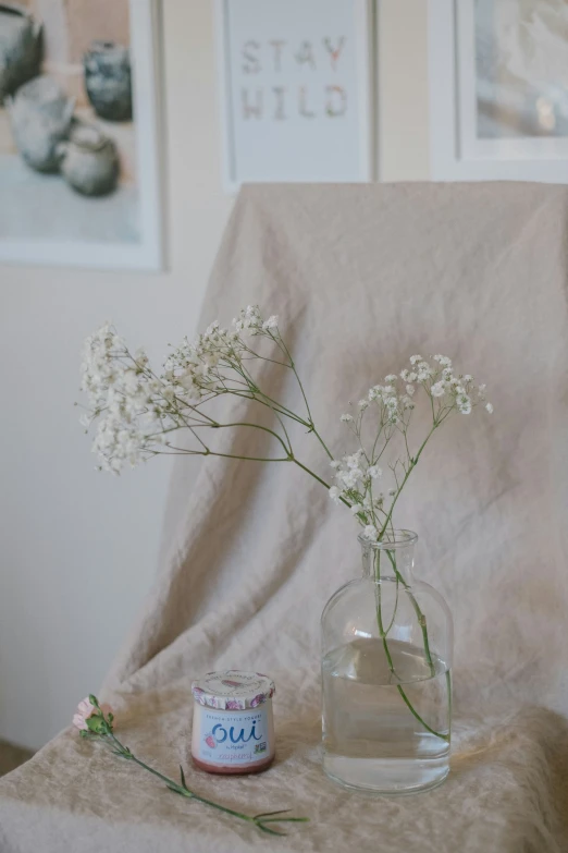 the vase has flowers in it near some small jars