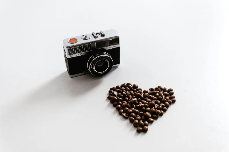 a heart shaped po frame sitting on top of coffee beans