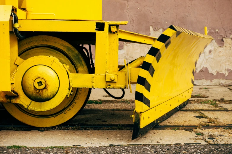 a close up of a yellow road roller