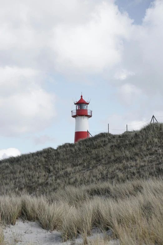 a red and white light house in the grass