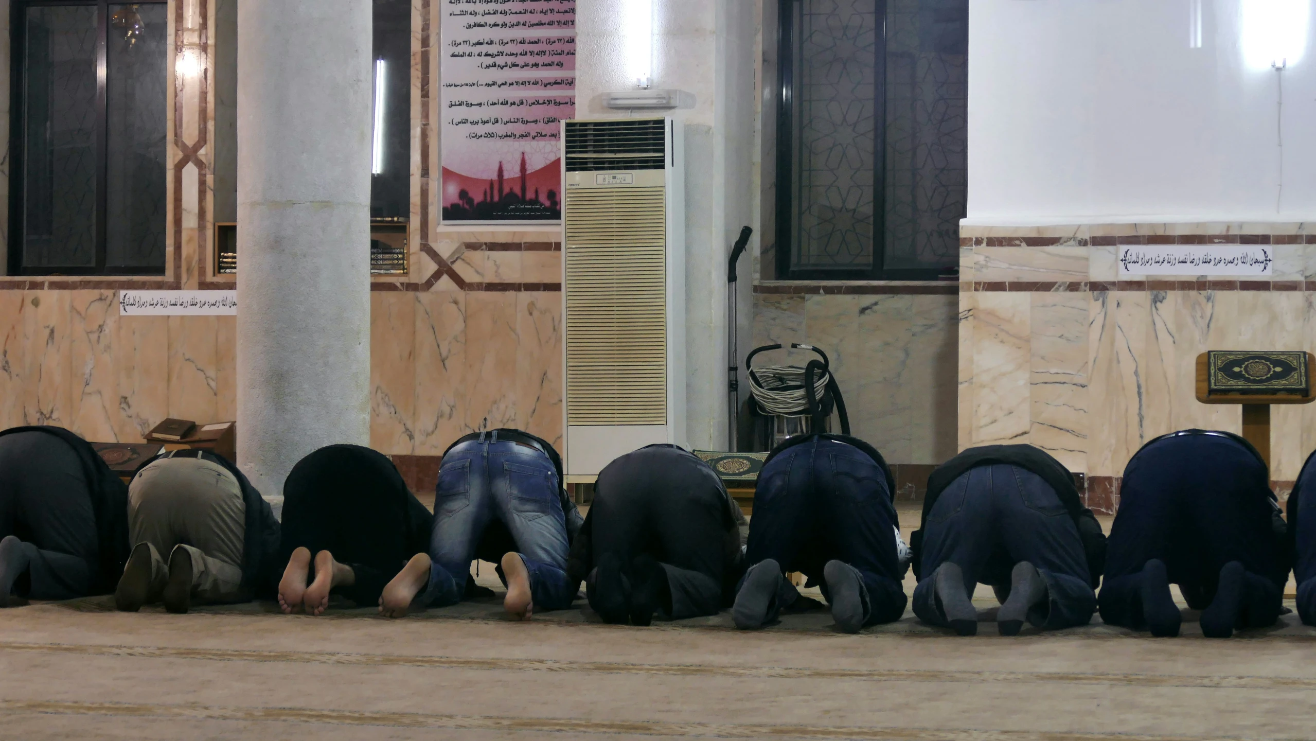 several people are sitting in a row in front of the entrance