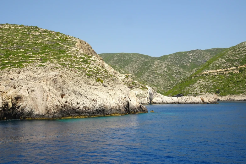 blue water in front of some green hills