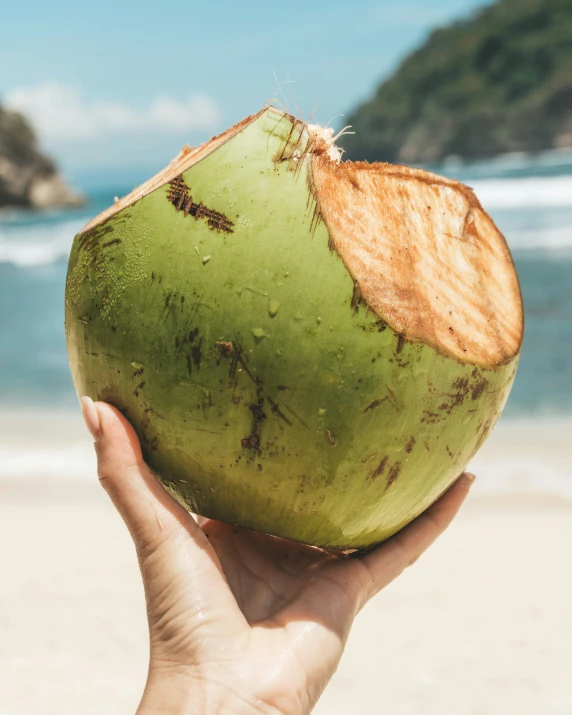 a person holding up a coconut that has been ed