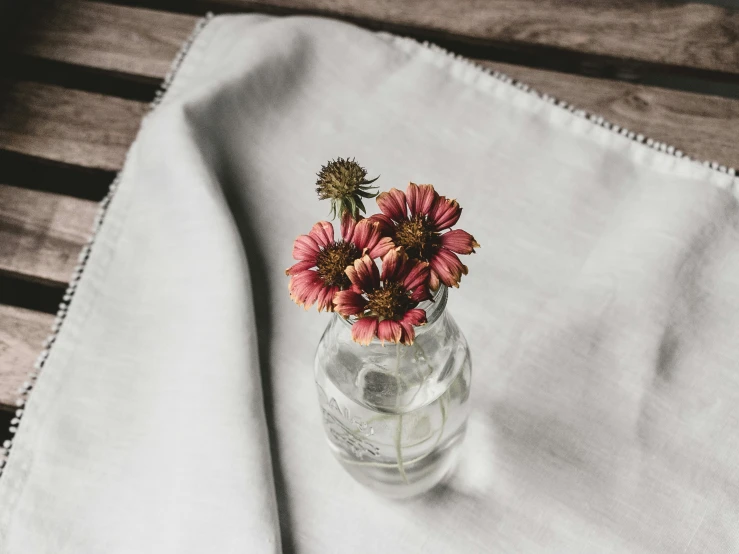 the small vase has flowers in it on the table