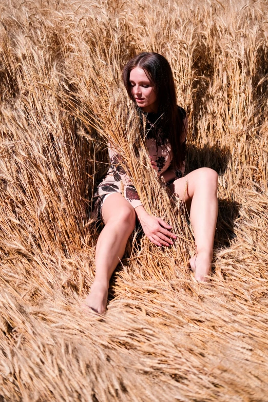 a woman is kneeling down in the tall grass