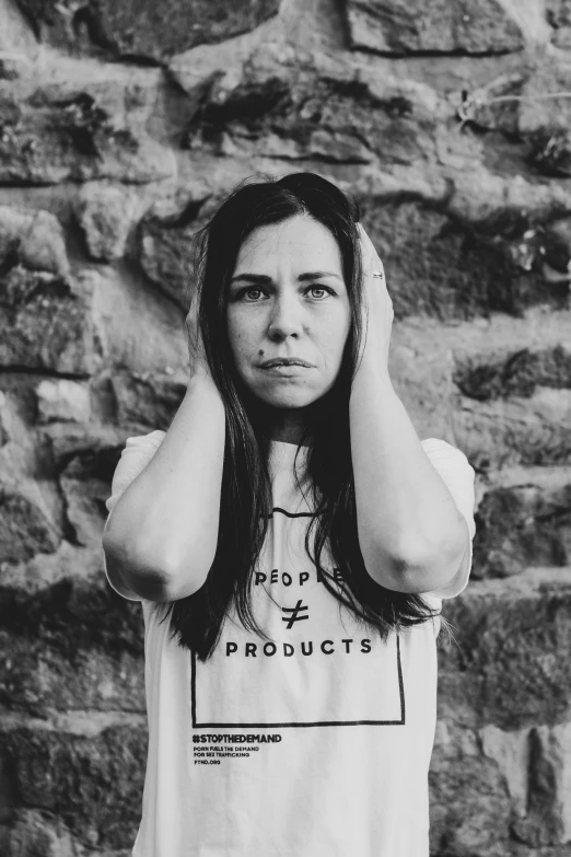 woman standing and covering her hair, wearing a shirt with the word  products on it