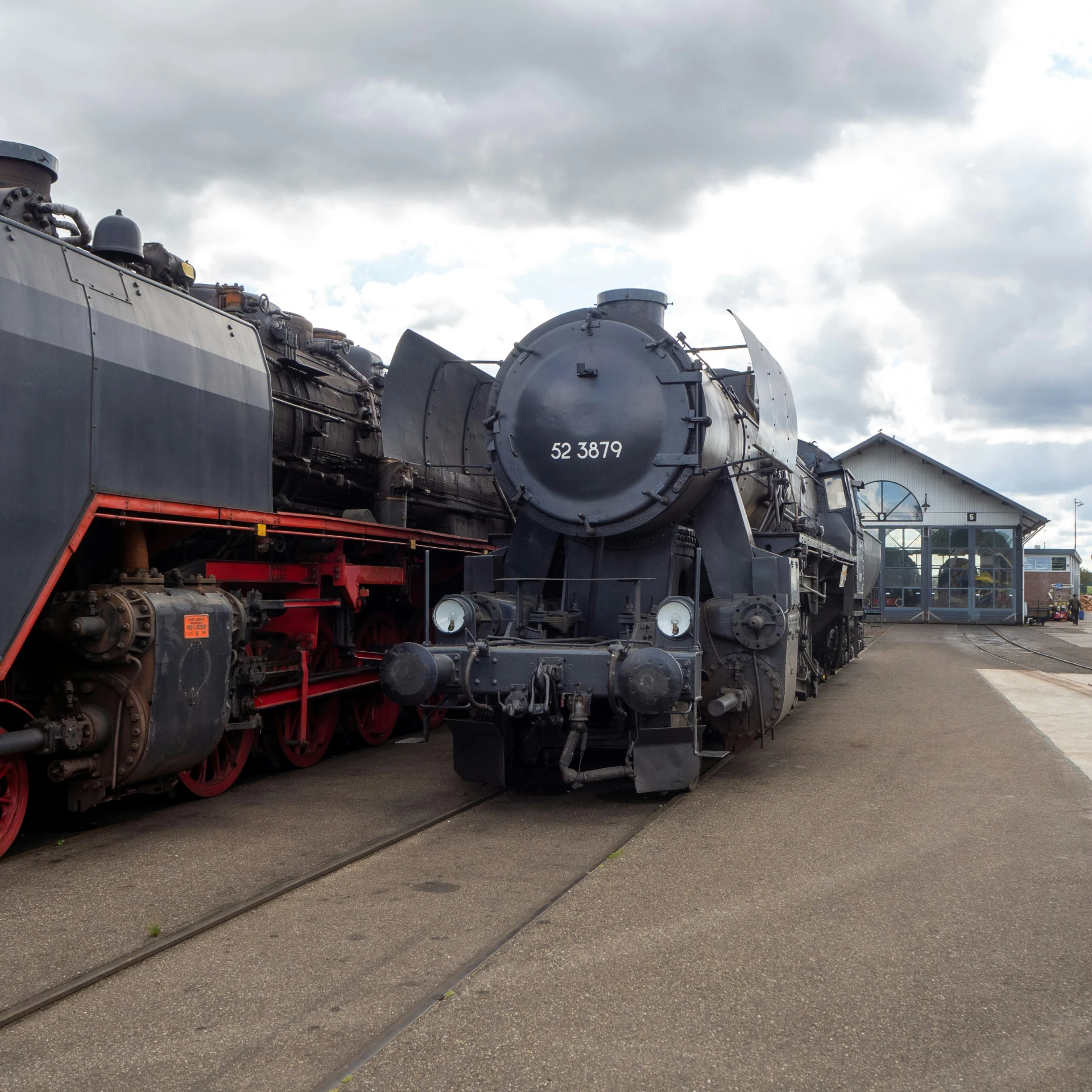 the old train is parked near an older structure