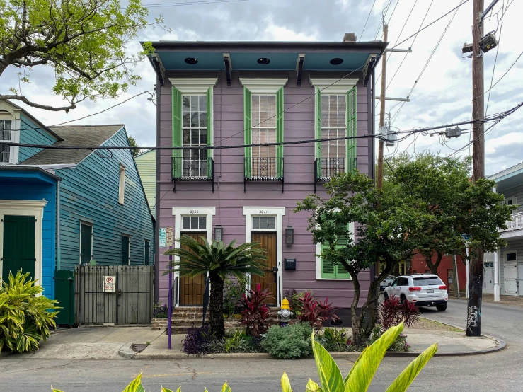 an old wooden house with blue trim and green shutters