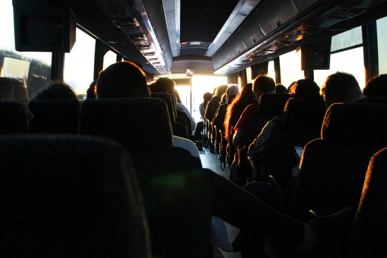 people riding in a bus with their shadows on the floor