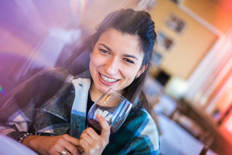 a woman smiles and holds a wine glass