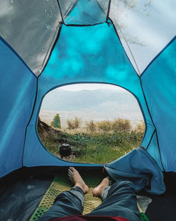 a man is inside his tent looking at the ocean