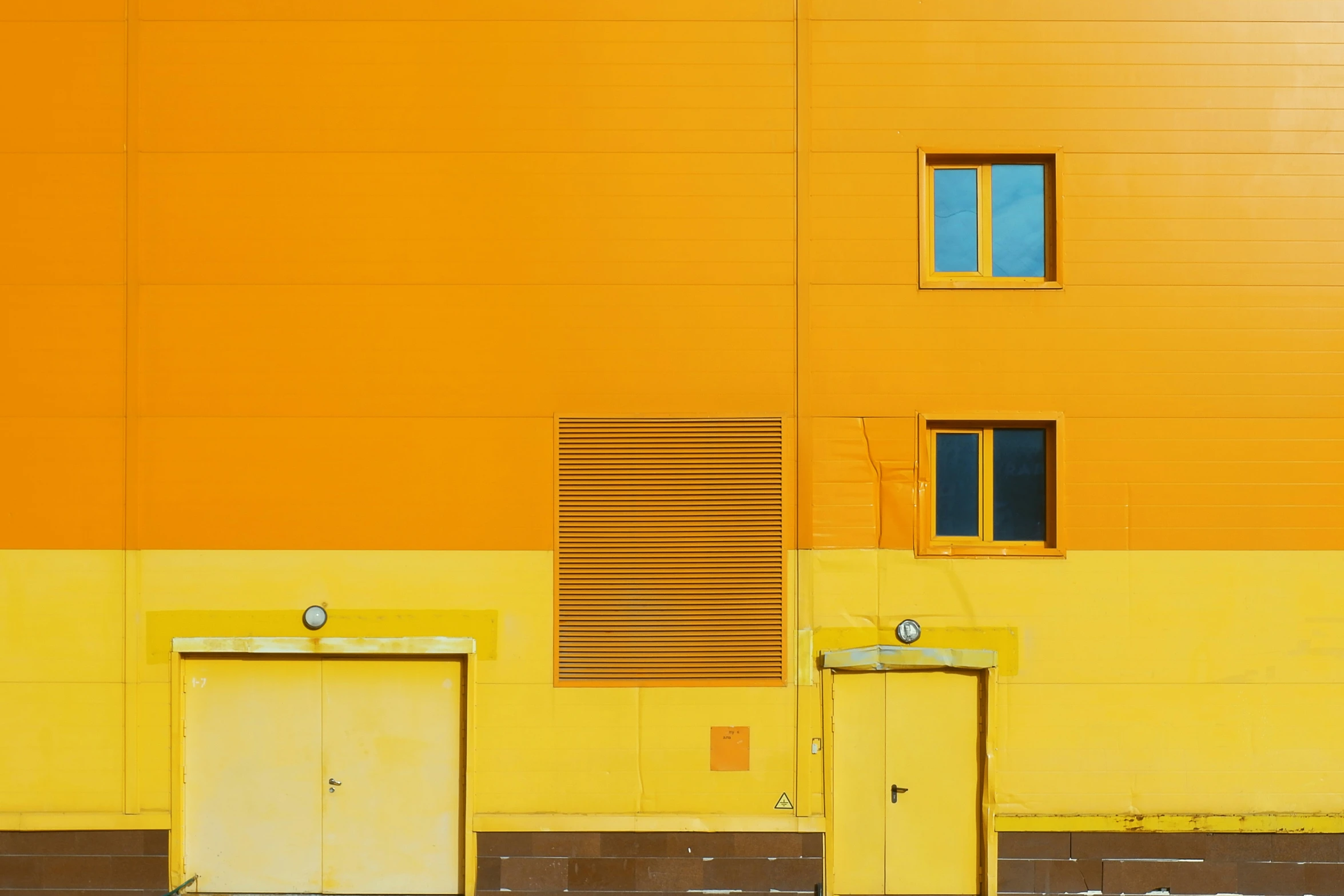 a yellow building with two doors in front