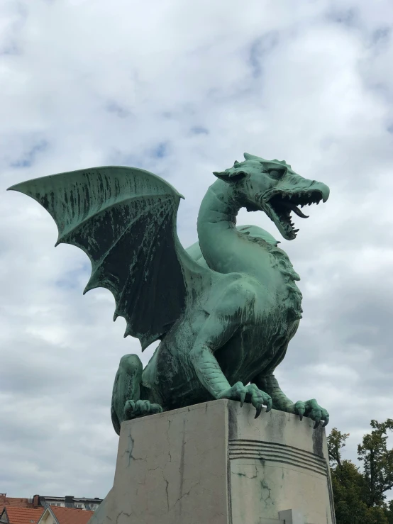 the statue of a green dragon with an outstretched tail