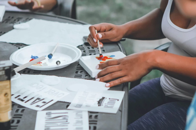 two women are painting soing on a table