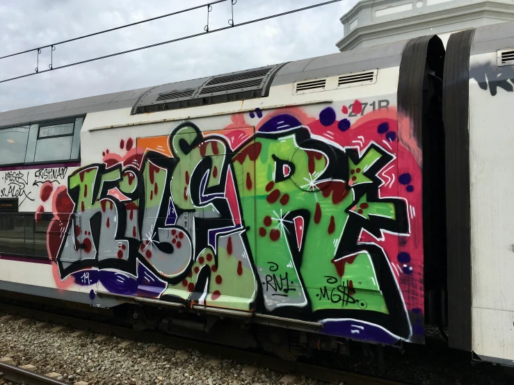 train covered in graffiti is on the tracks