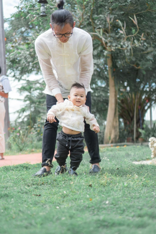 a man is helping a child play with a doll