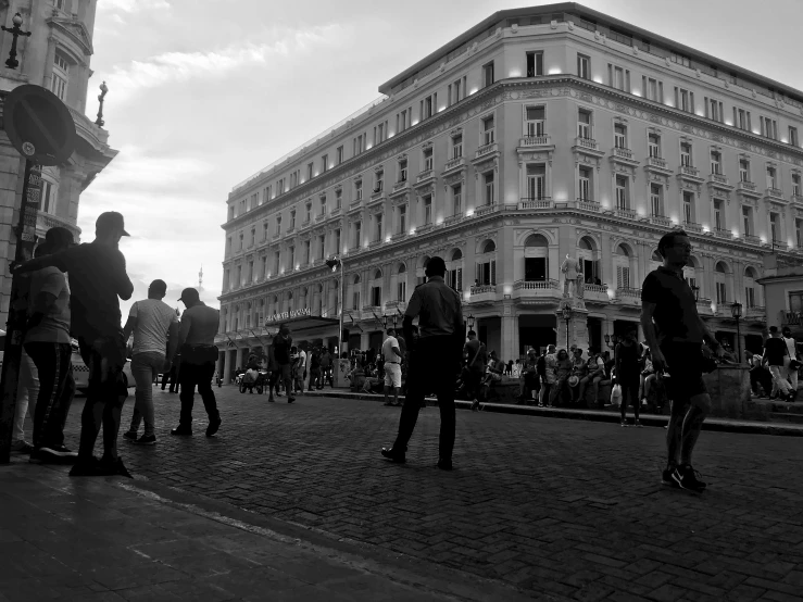 a group of people walking down a sidewalk near a building