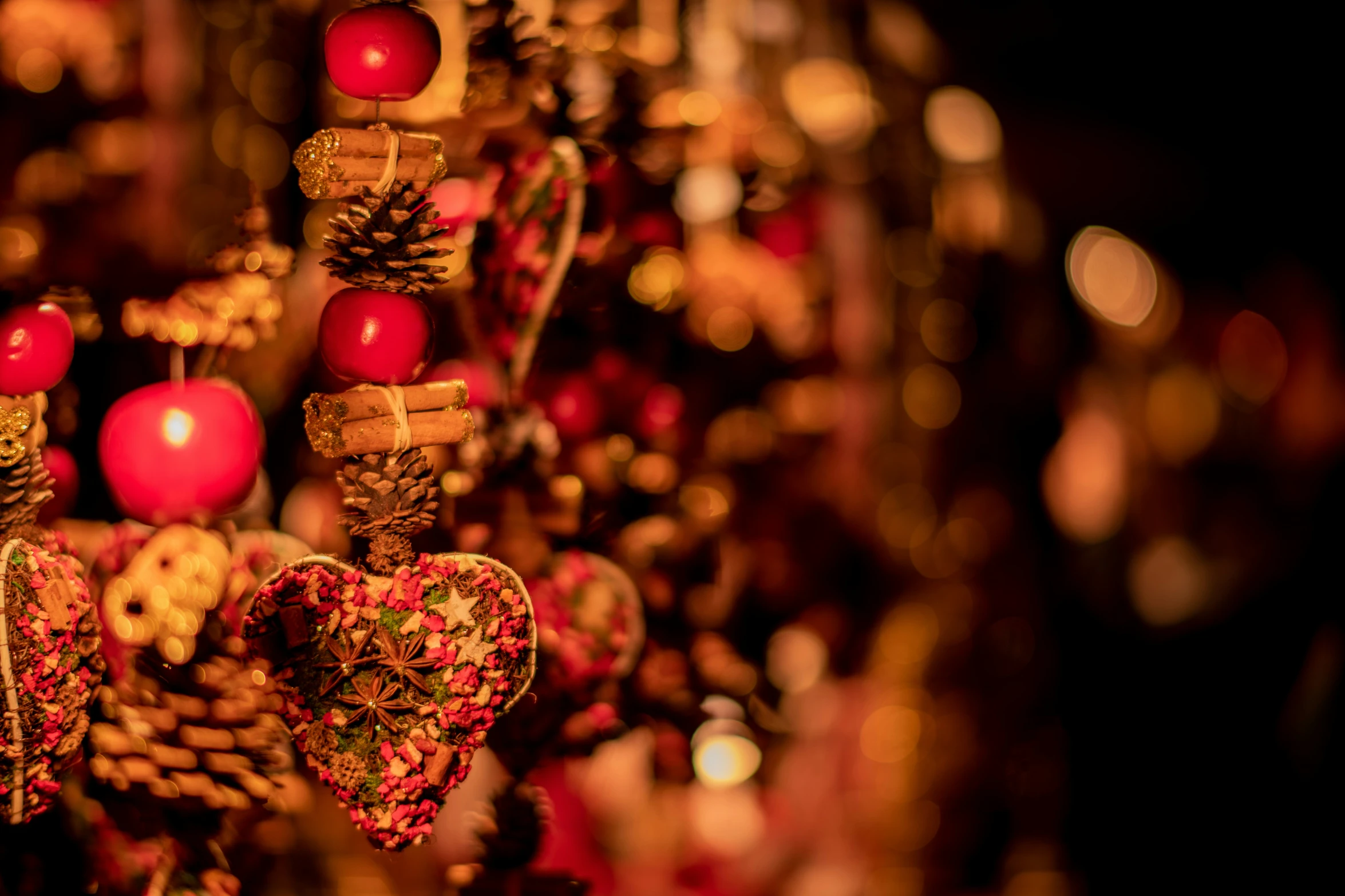 several red ornaments that are hanging from chains