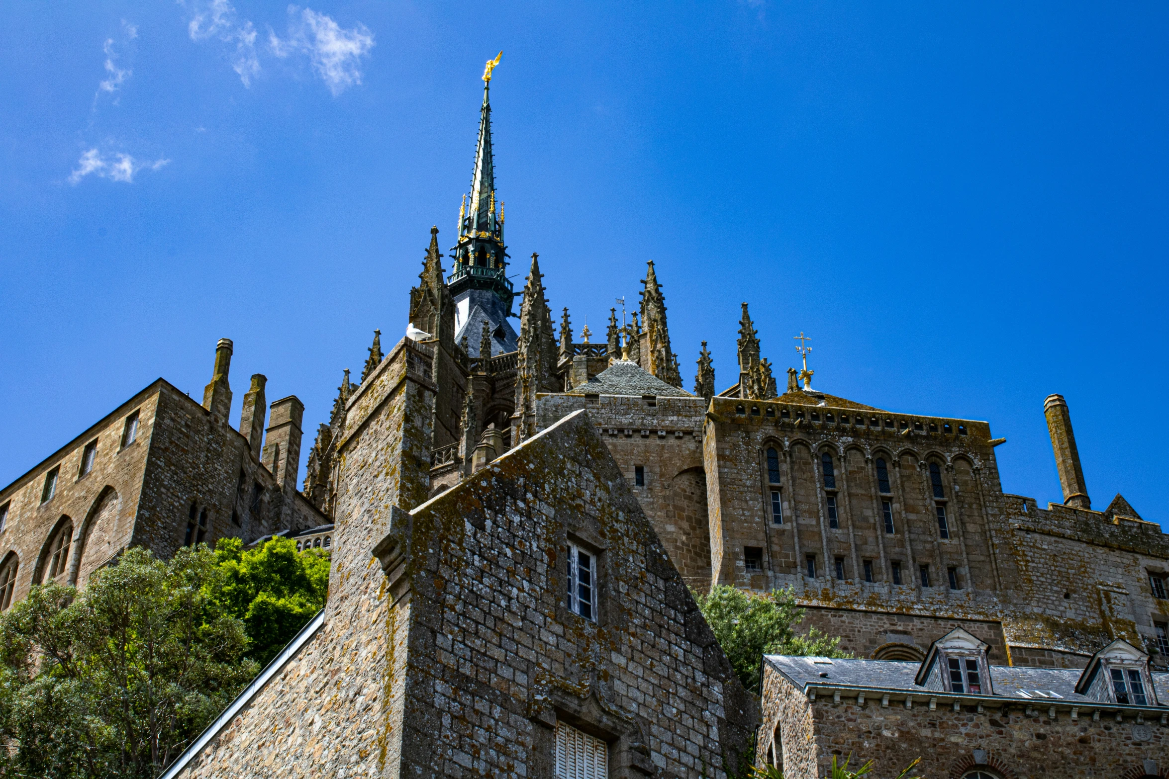 the spire and entrance of a castle on a sunny day