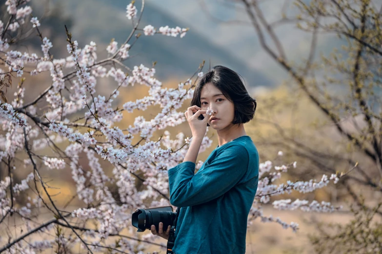 a woman standing with a camera on a cell phone