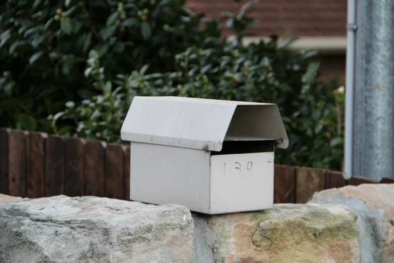 a mailbox that is in the rocks next to a fence