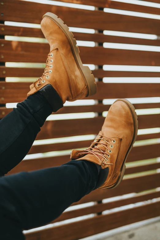 a pair of legs sitting on top of a wooden bench