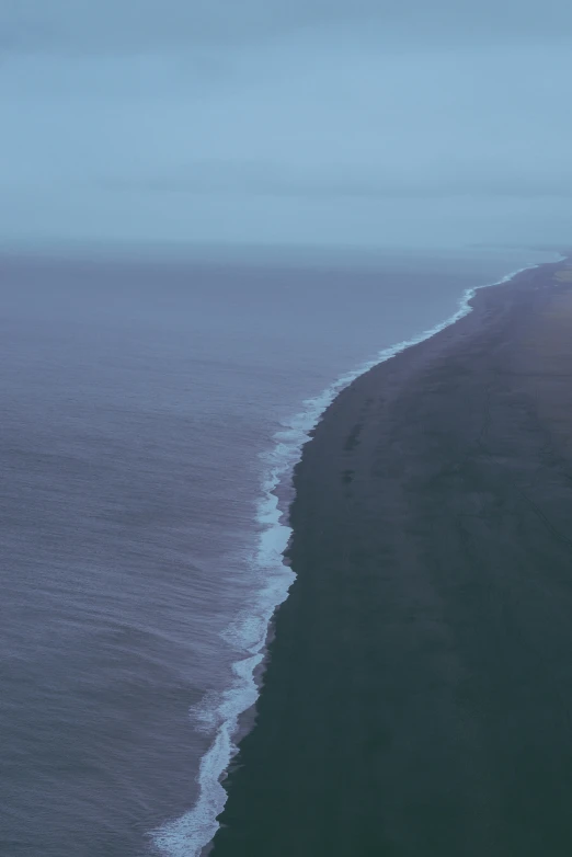 a view from above of a black sand beach