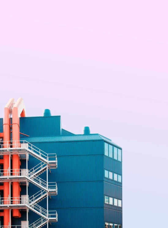 a tall blue building with orange and white stairs