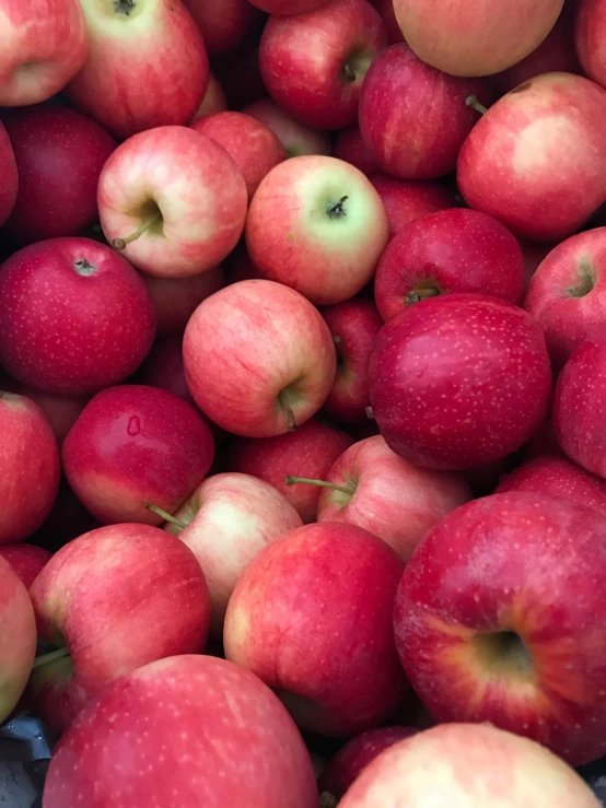 closeup of many apples for sale on a sidewalk