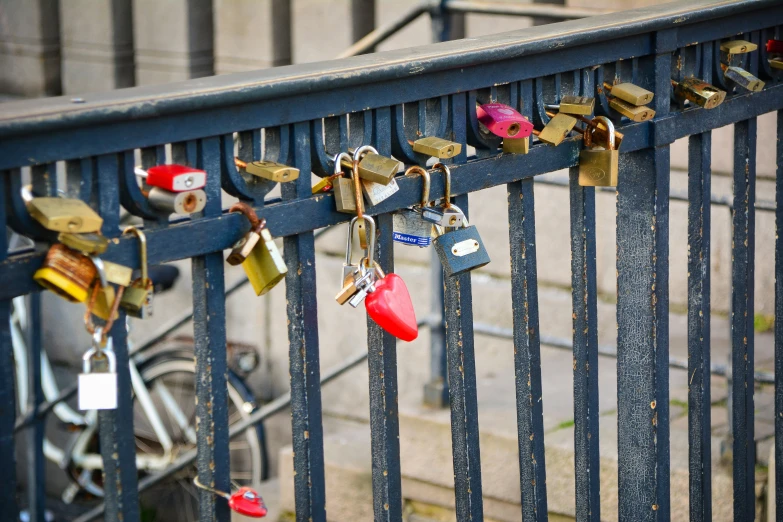 colorful locks and hearts attached to a metal fence